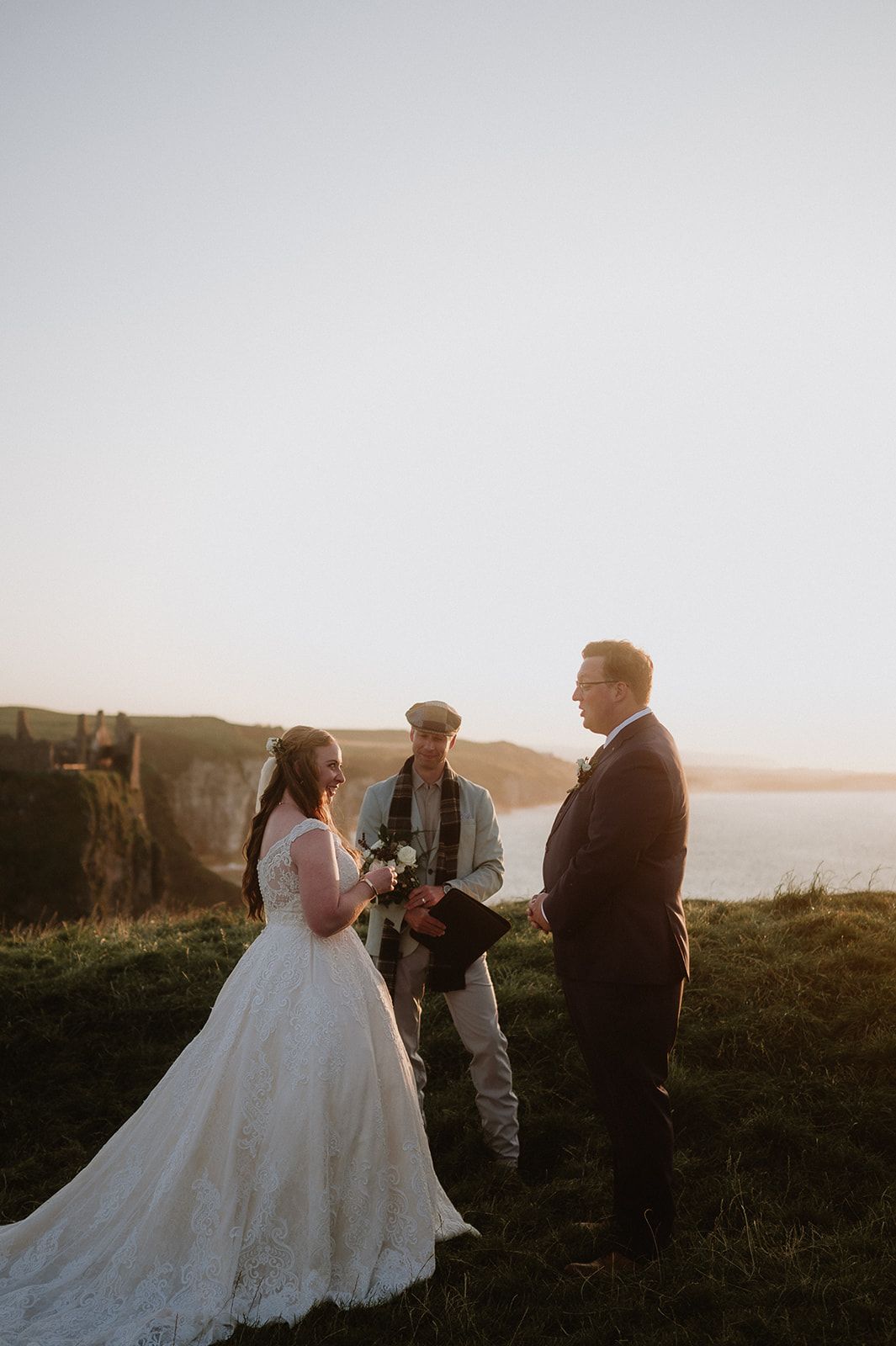 Bride recites his vows as he and his bride renew vows in Ireland with cliffs in the background