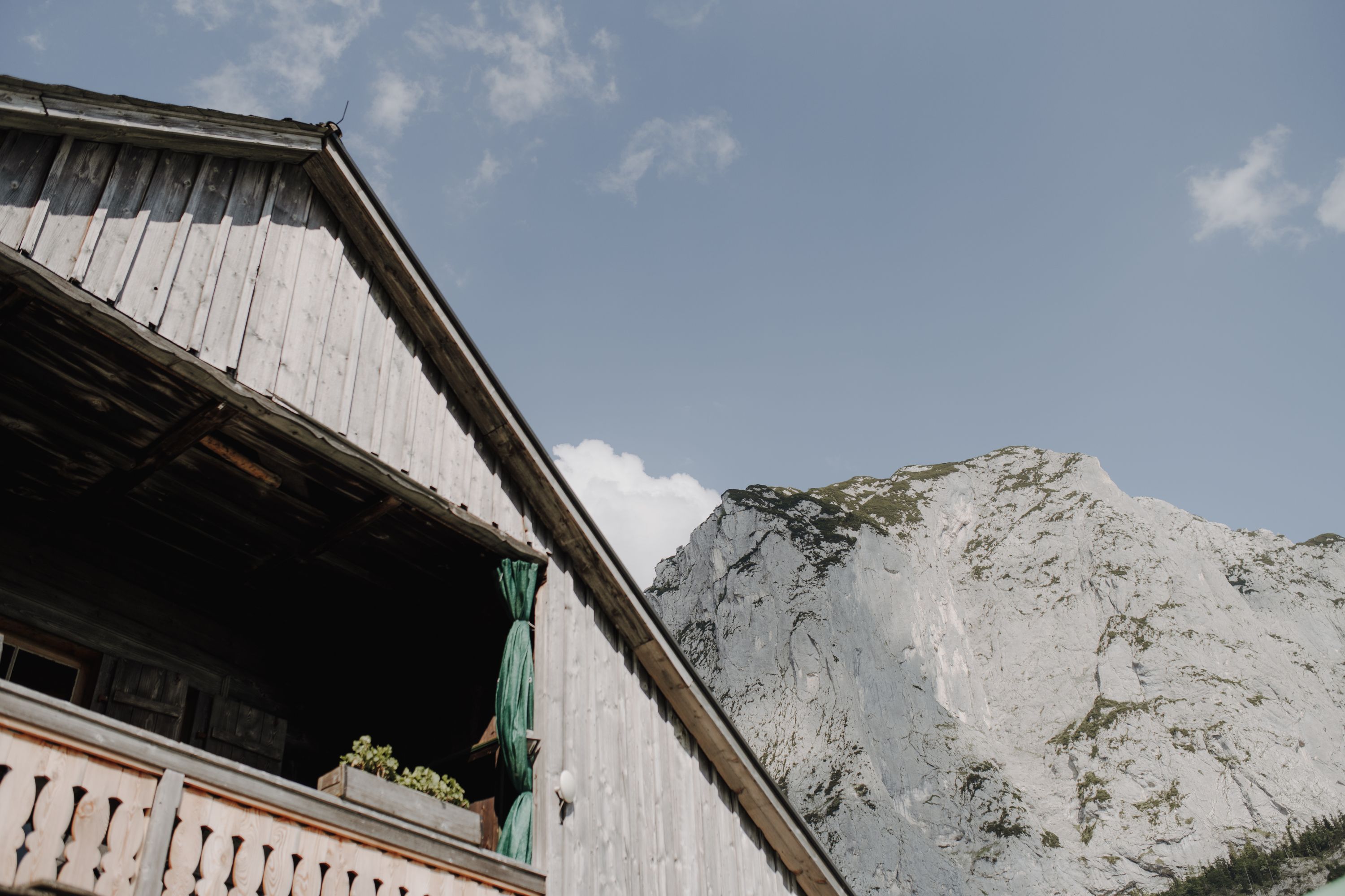 Weathered timber chalet under a limestone peak in the Austrian Alps