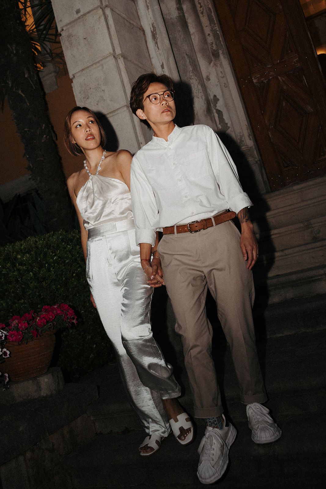Two brides wearing casual white clothes during their micro wedding in Portugal at a hotel along Cascais bay