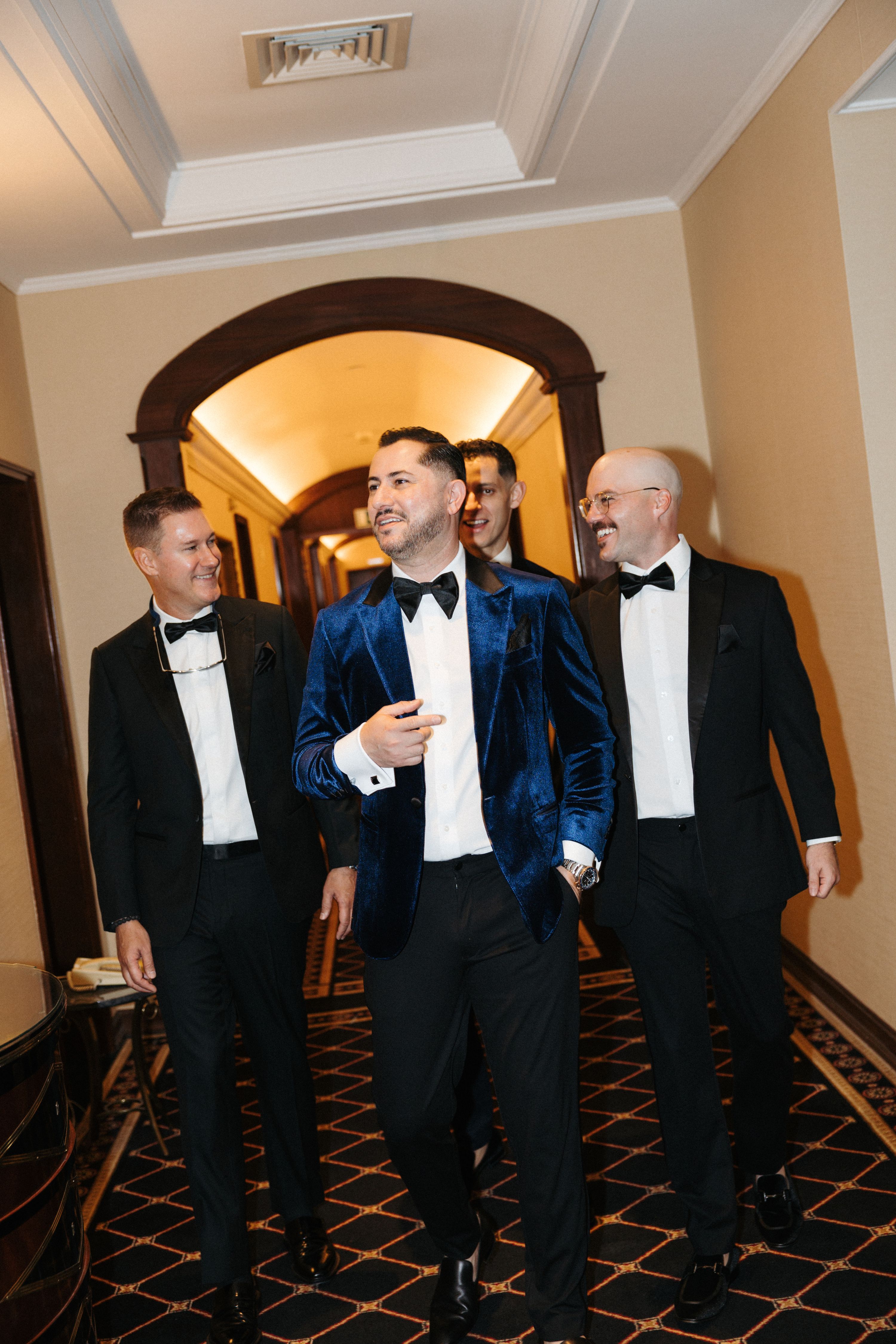 Groom relaxed and walking with his groomsmen inside the hotel where they got ready for his small wedding in Portugal