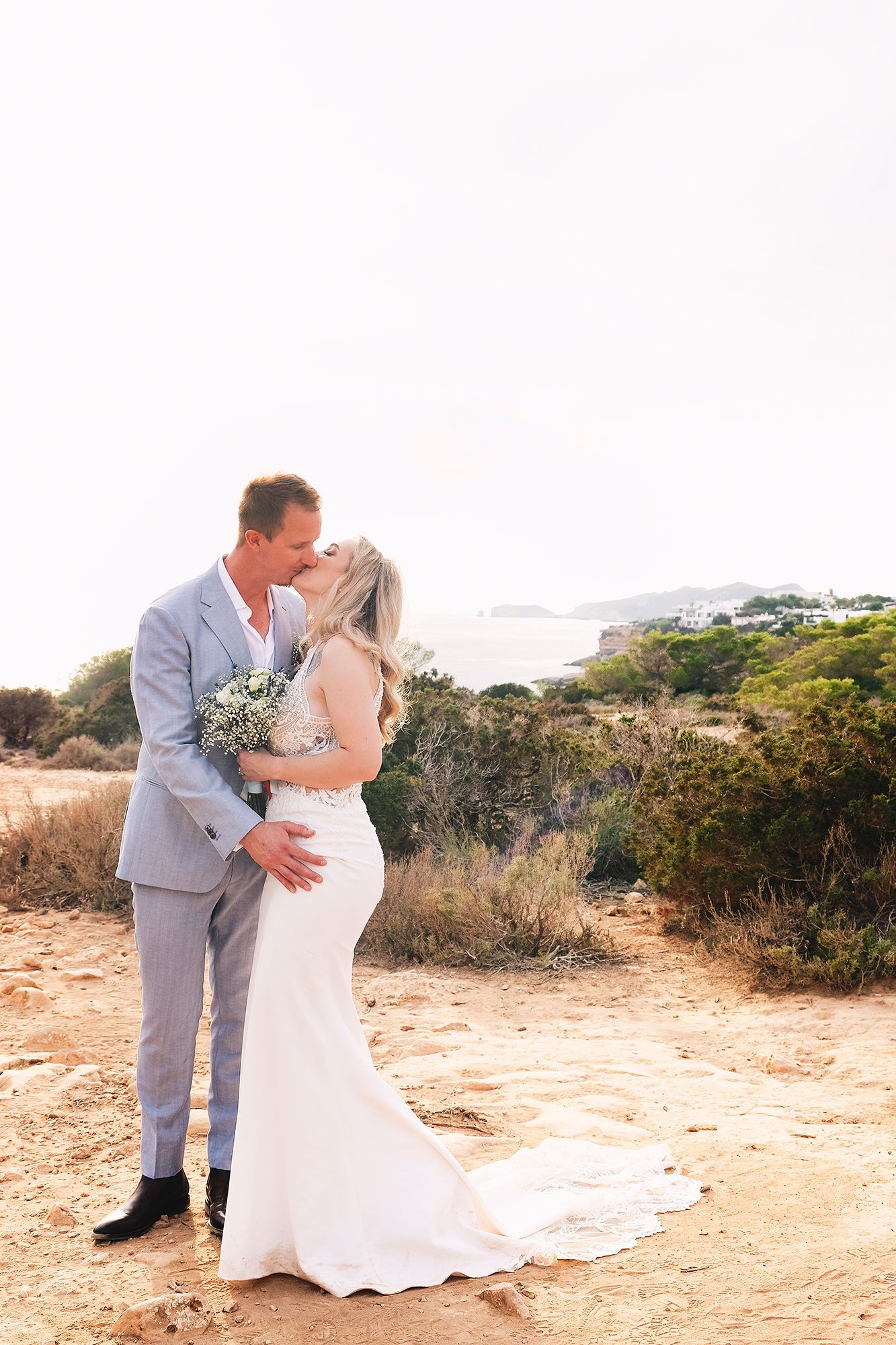 Bride and groom kissing each other in an outdoor setting of their destination elopement in Ibiza, Spain