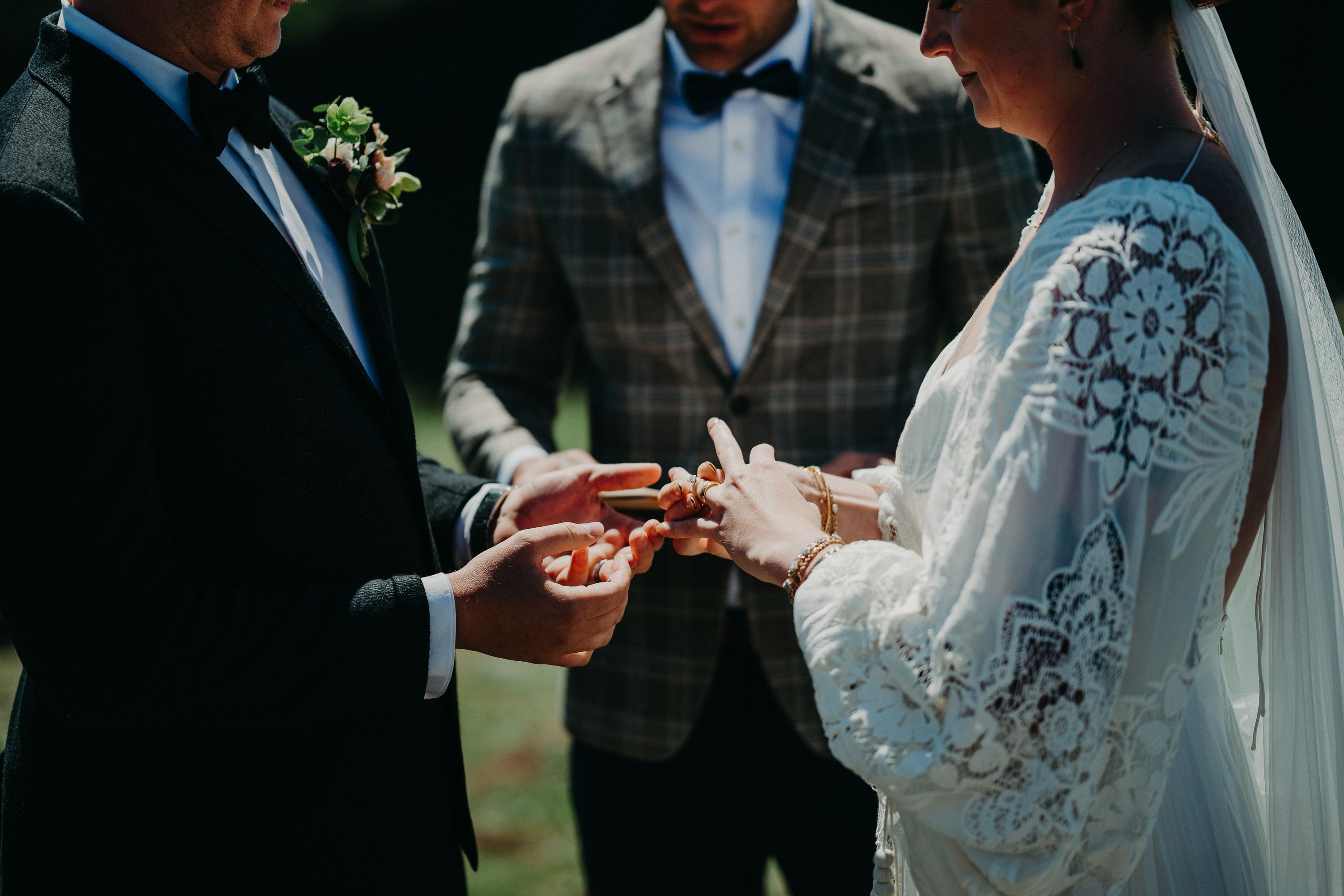 A couple exchanging rings while an officiant looks on during their intimate wedding in Ireland