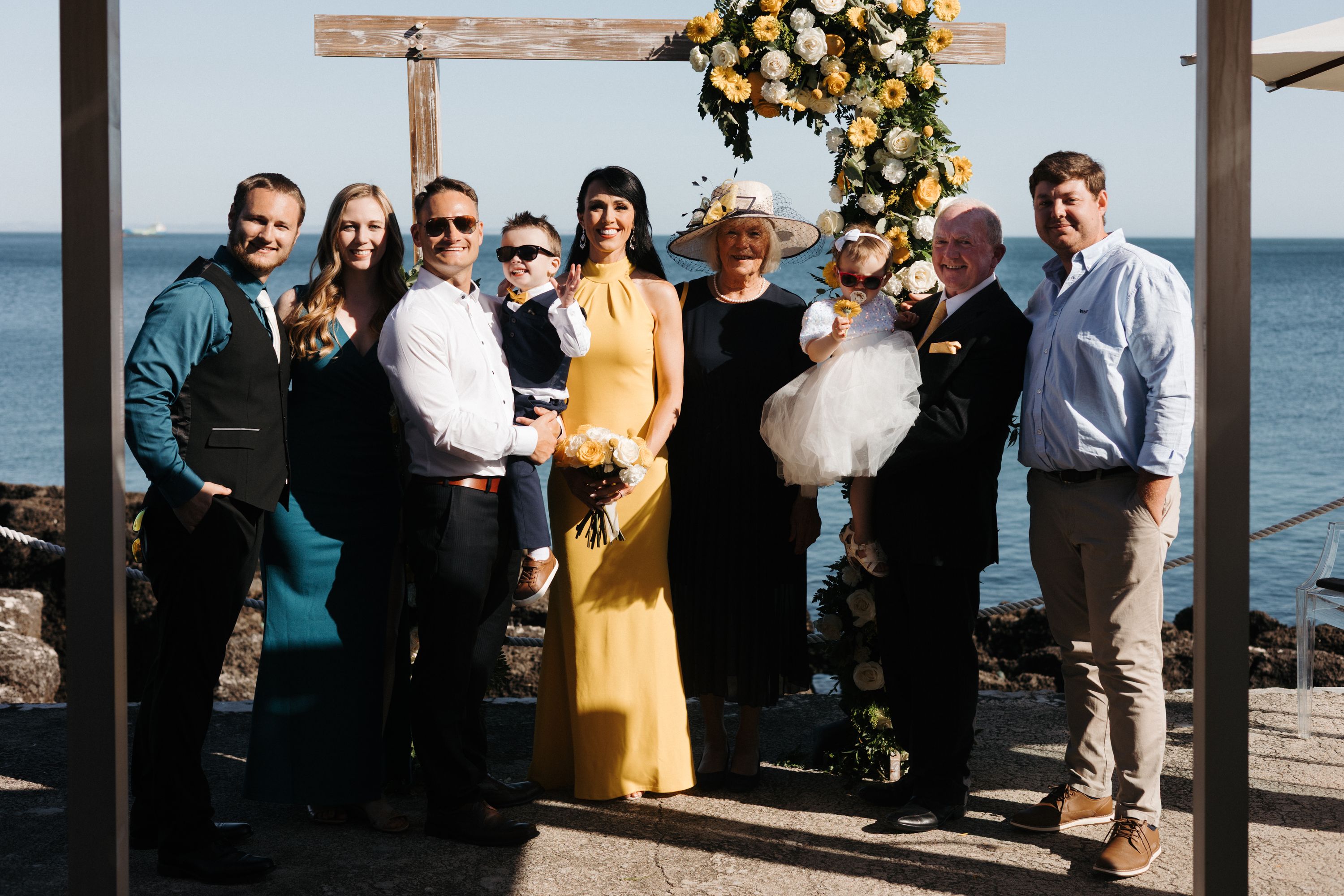 Guests get their photos taken with the Cascais coast in the background during their small wedding in Portugal