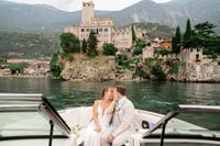 Newly eloped couple kiss during their boat ride along Lake Garda after the ceremony of their elopement in Italy