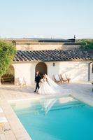 Bride and groom walking on the poolside of the boutique hotel where they Tuscan venue where they got married in Italy