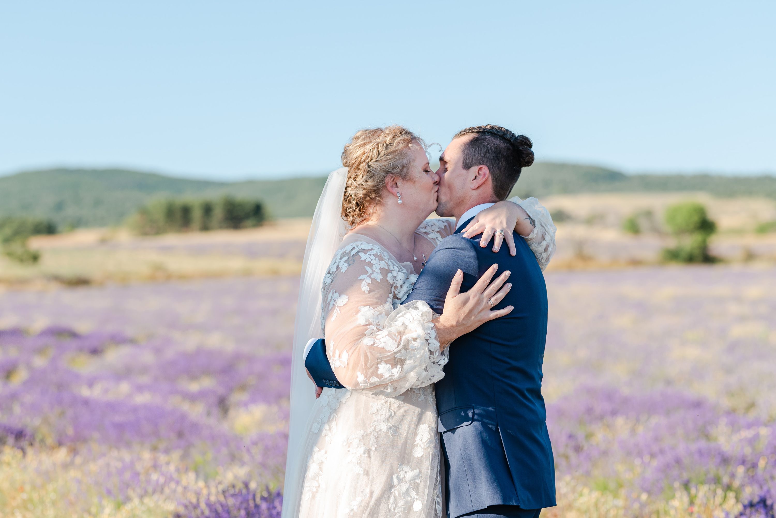 Romantic kiss surrounded by Provençal lavender fields during a small wedding in France