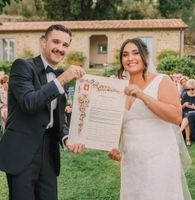 Bride and groom smiling as they hold a document evidencing their destination wedding in Italy