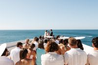 An intimate wedding in Portugal with the bride and groom in front of their guests on a clifftop outdoor ceremony in Algarve