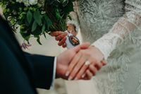 Couple's hands holding each other, showing a photo of a man in the bride's bouquet when they got married in Ireland