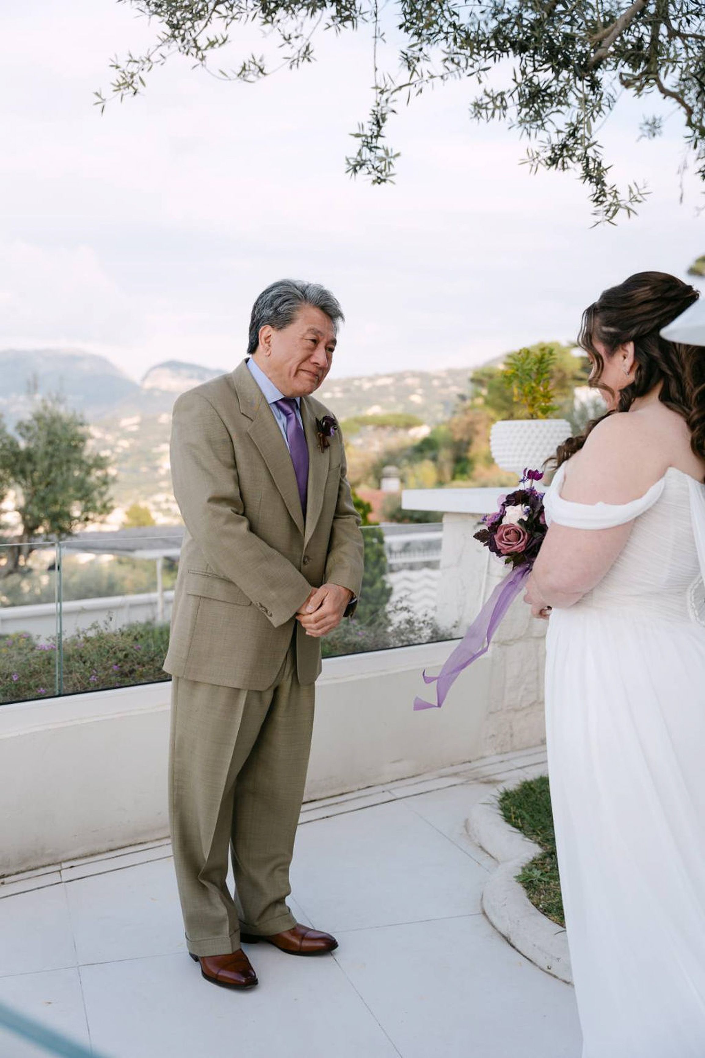 Emotional first look between bride and groom at an intimate wedding in Italy with coastal views