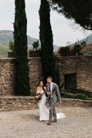 Bride and groom walking along a cobbled street with tall trees in the background during their small wedding in Portugal