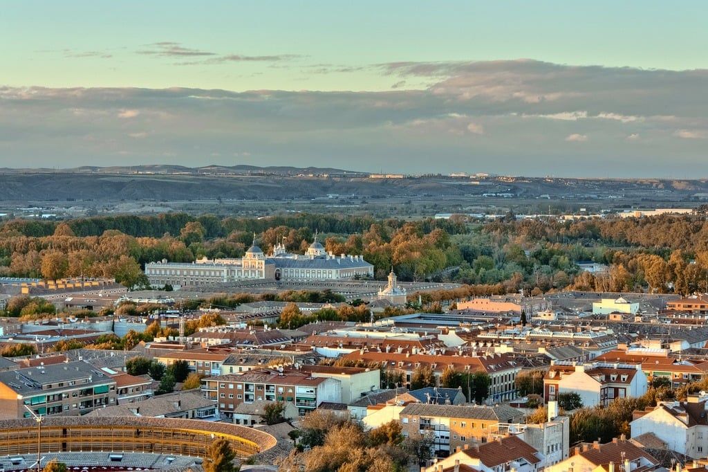 A modern Spanish cityscape with modern buildings and some forested areas