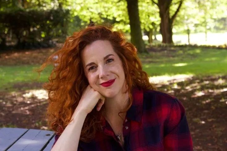 Our wedding planner in Ireland wearing a red and black shirt with a forest background