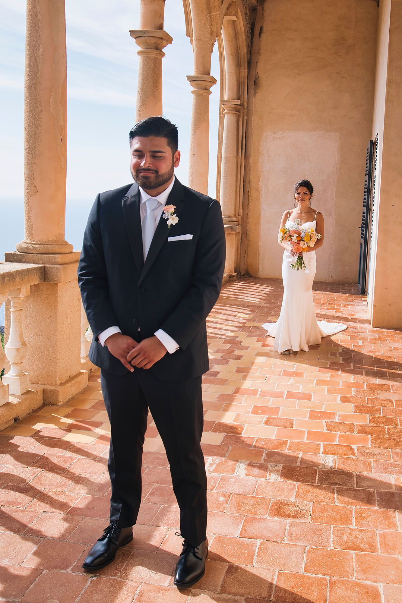 Groom waits for his bride during the first look of their intimate wedding in Spain atop a cloister in Mallorca