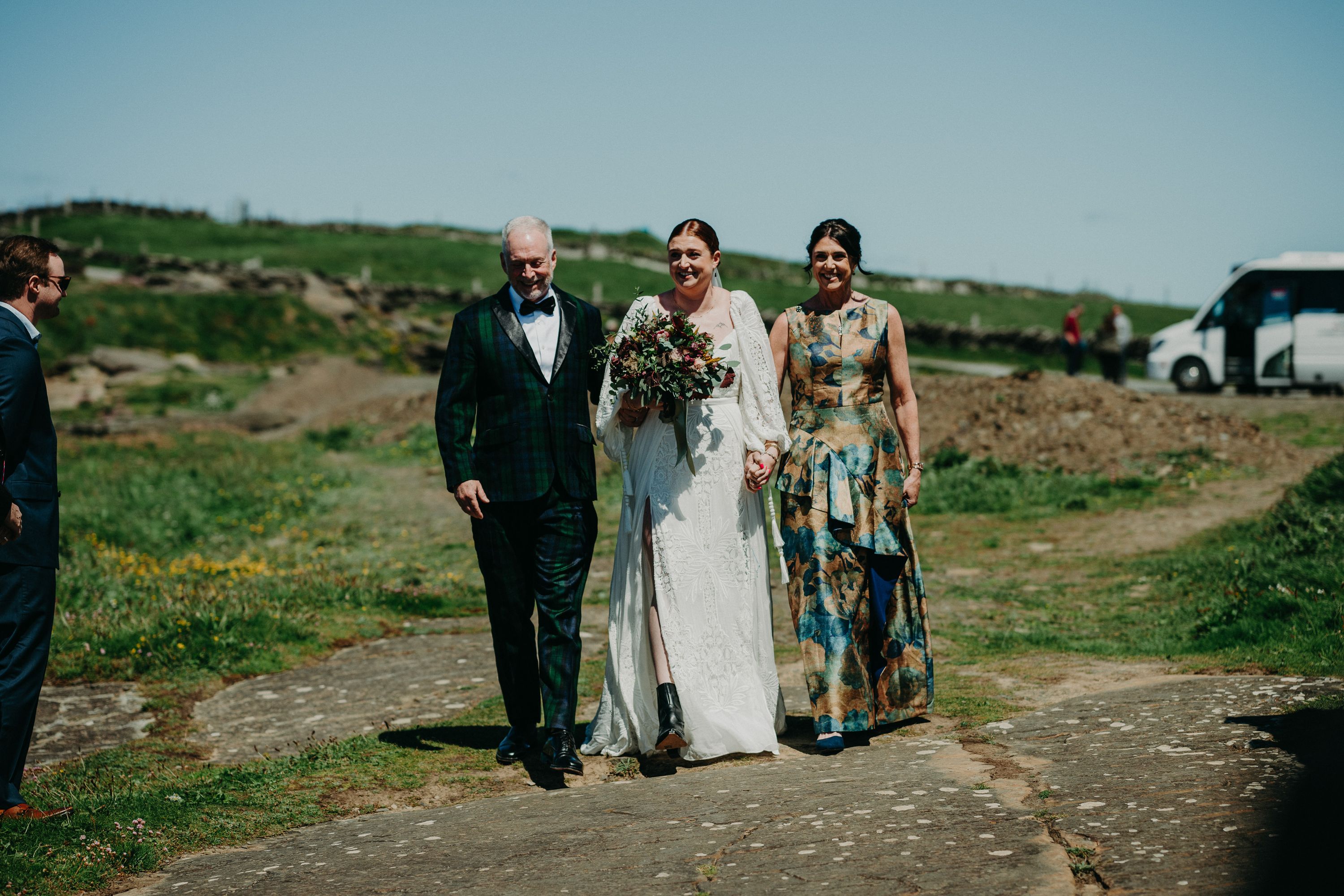 The bride's parents walking beside her on her way to the groom for their small wedding in Ireland