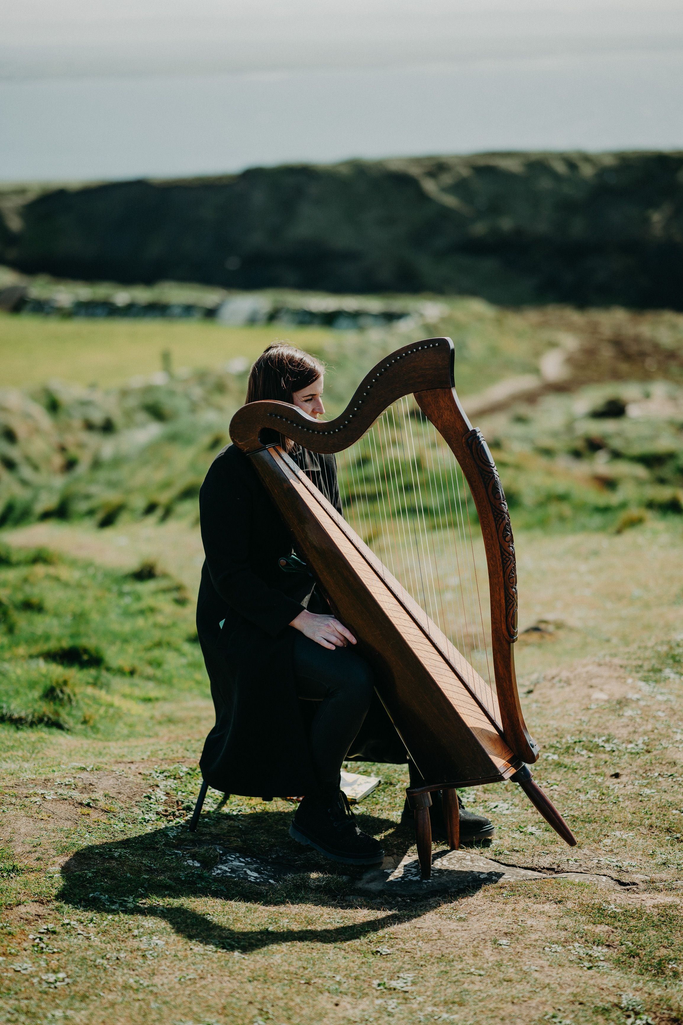 A musician playing a harp for an intimate wedding in Ireland