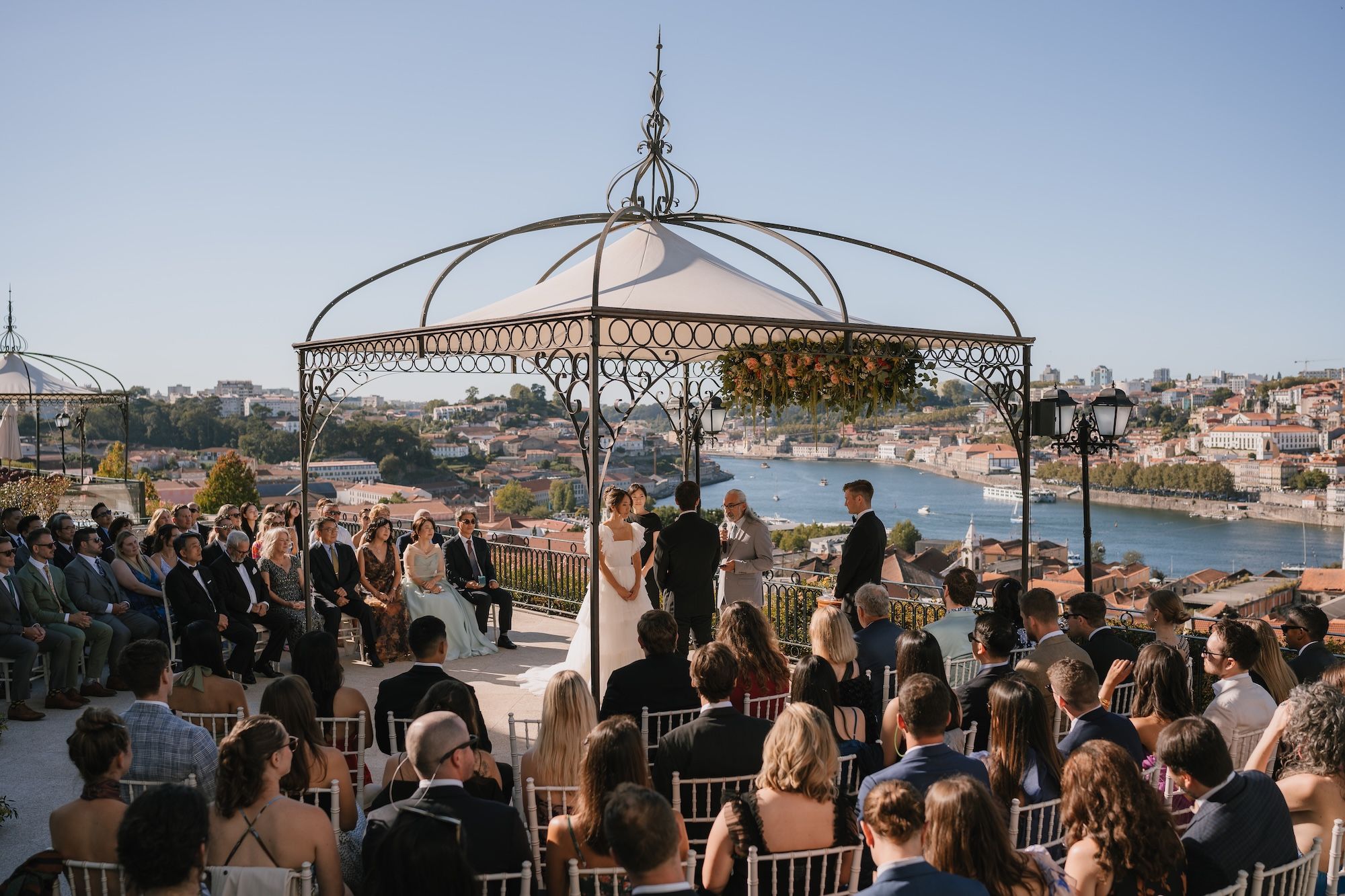Bride and groom having a ceremony for their intimate wedding in Portugal in front of their guests on a terrace of a hotel