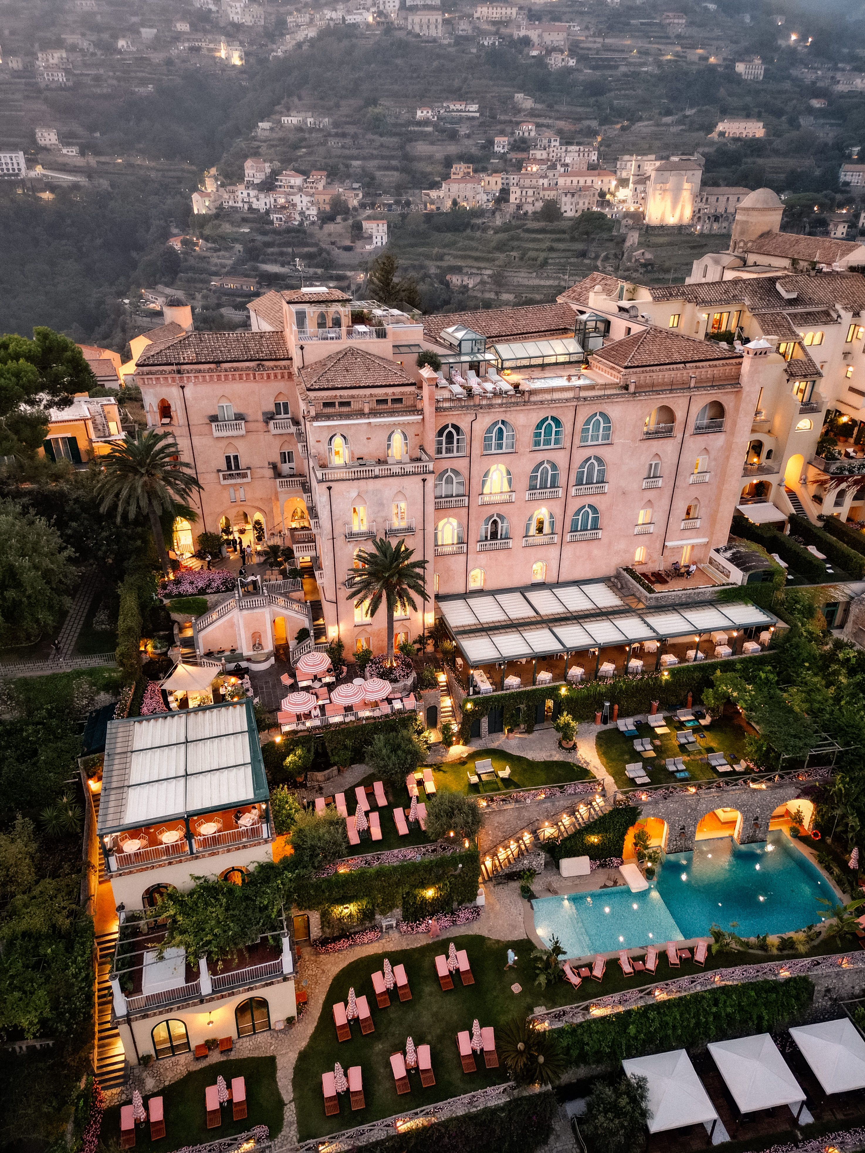 Drone shot of an elegant and historic looking hotel in Italy with a pool and several buildings around it