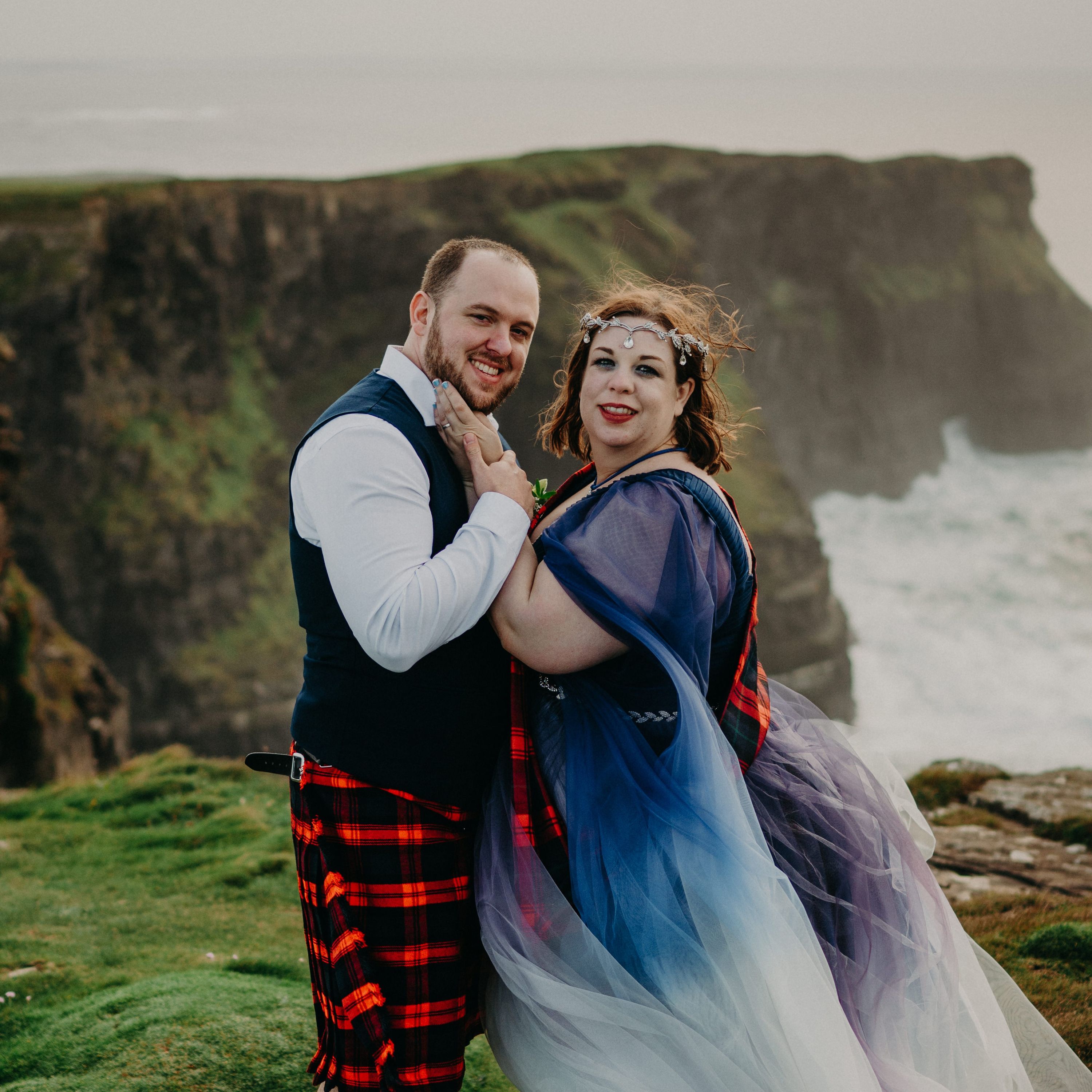Bride and groom looking at the camera on top of a Hags Head after the ceremony of their destination wedding in Ireland