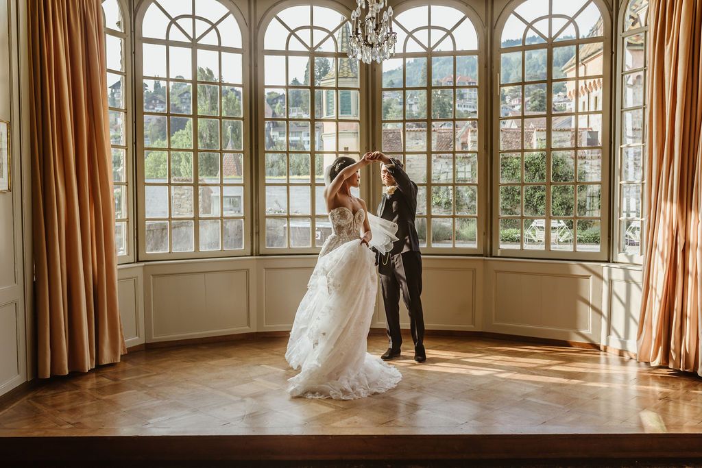 couple dancing in front of a Switzerland backdrop behind the windows