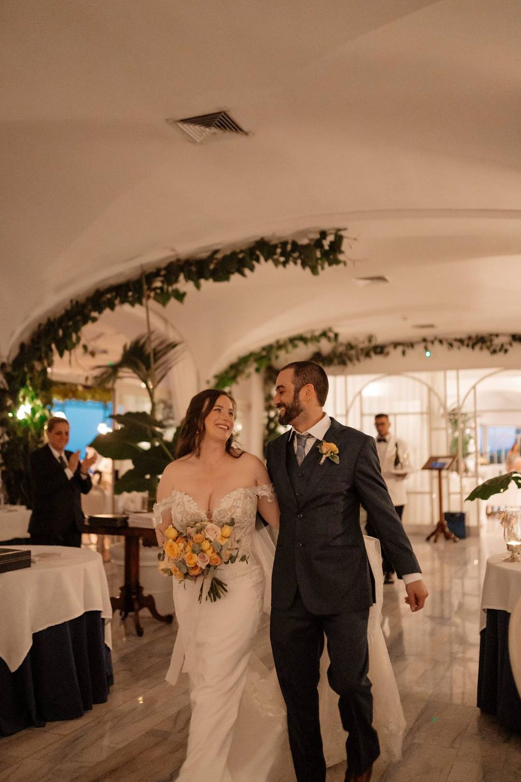 Newlyweds happily walking inside a restaurant in Amalfi Coast during the intimate dinner of their elopement in Italy