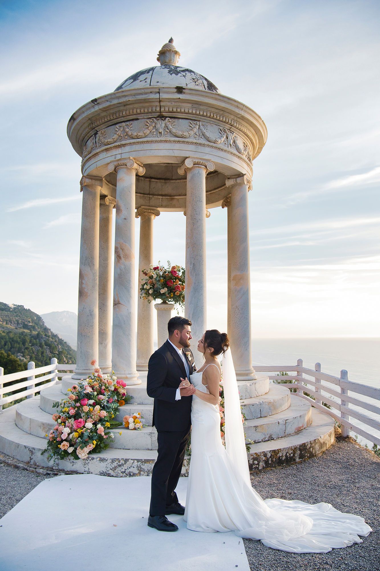 Newlyweds looking at each other with an iconic marble temple in the background during their small wedding in Spain