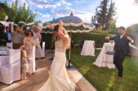 Bride and groom dance as their guests welcome them to the outdoor dinner reception of their destination wedding in Spain