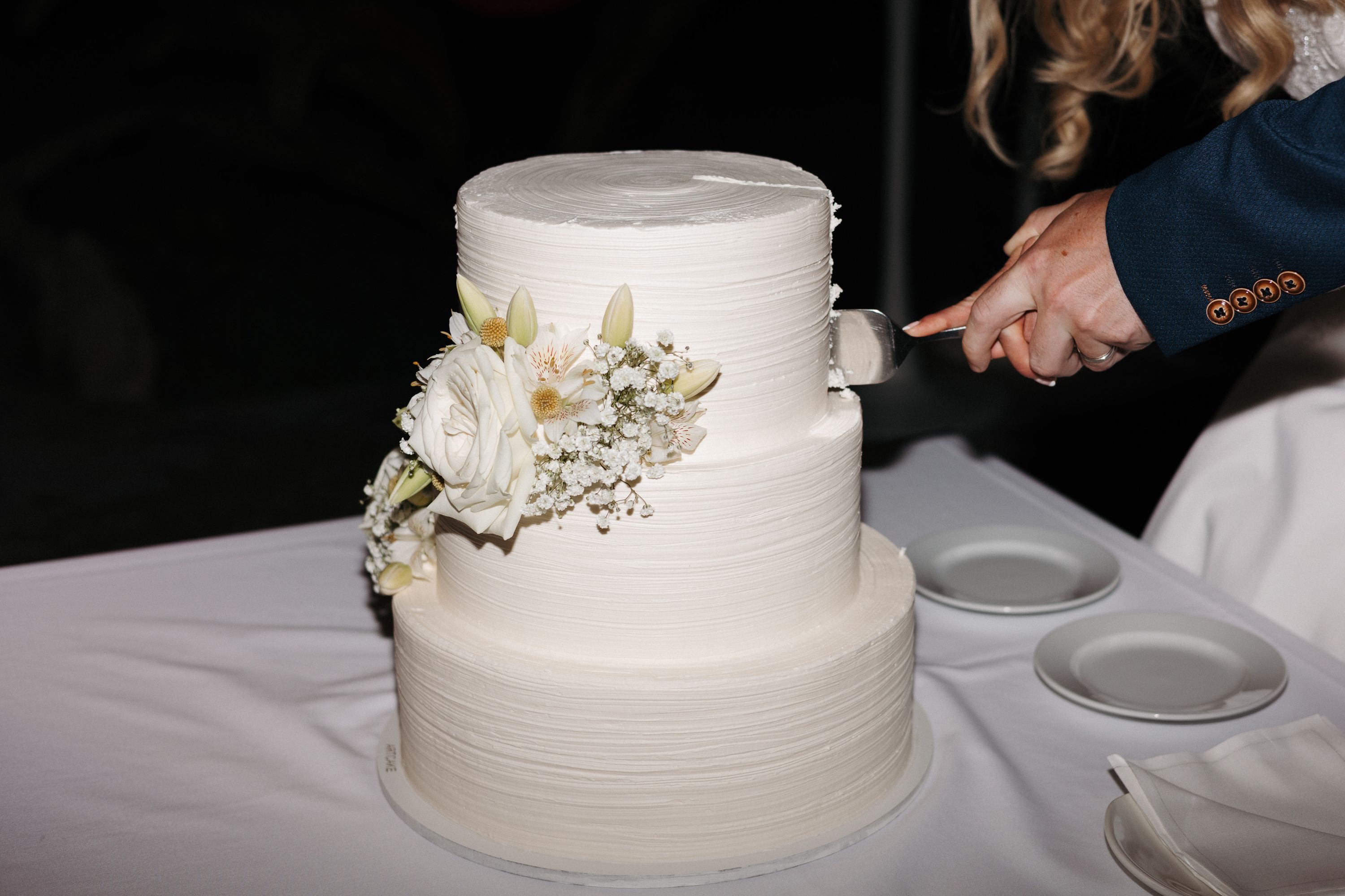 Couple cutting a classic white wedding cake during an intimate wedding in Portugal