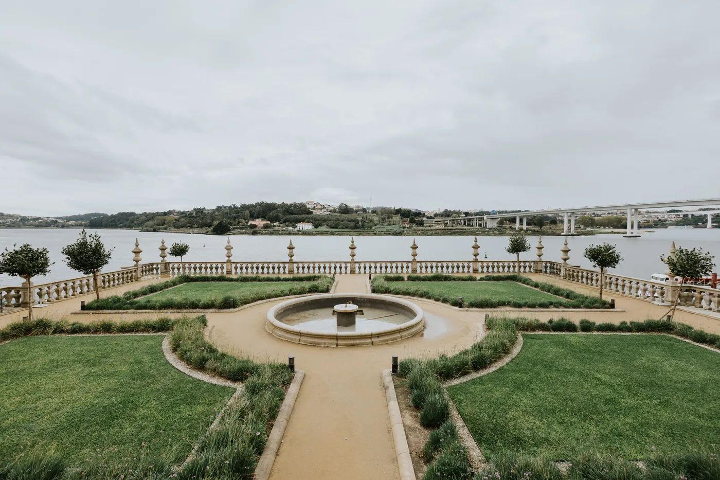 A working fountain in the middle of a formal garden of a wedding venue in Portugal, overlooking a river