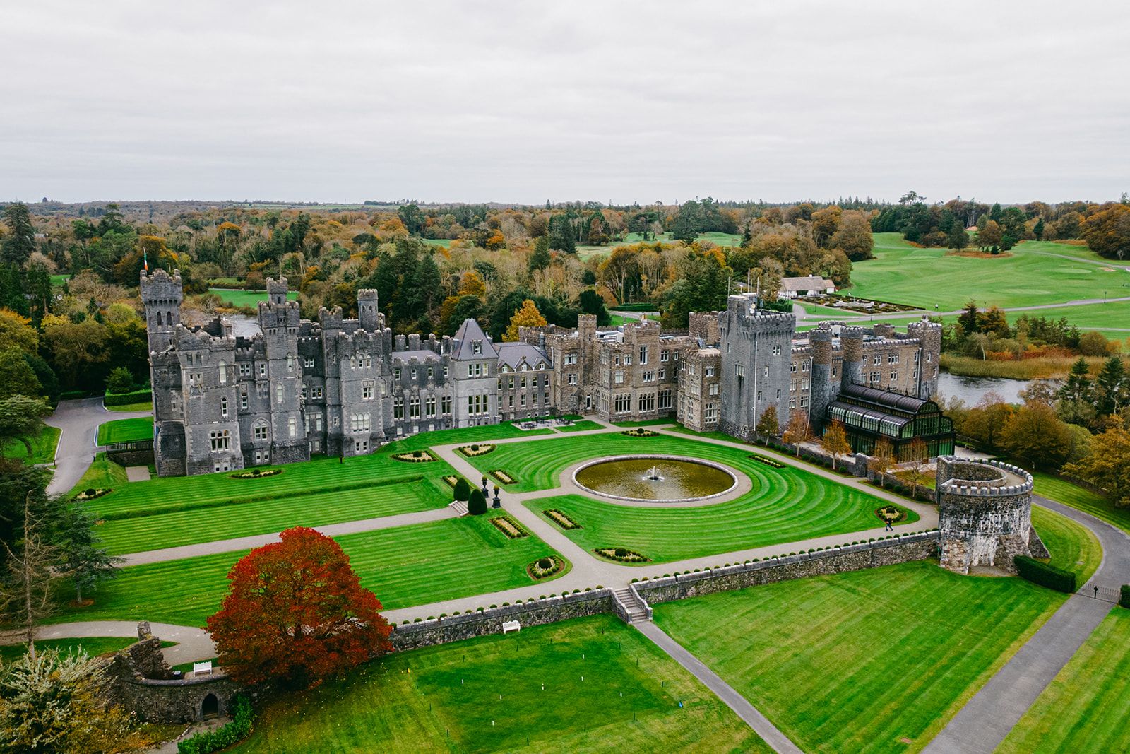 Drone shot of a medieval picturesque castle in Ireland within a large estate filled with lush greenery