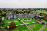 Drone shot of a medieval picturesque castle in Ireland within a large estate filled with lush greenery