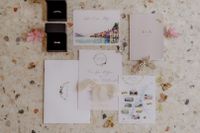 Flat lay of invitations and rings on a table for an Italian destination wedding