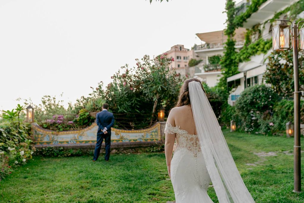 Bride is walking towards her groom during the first look of their destination elopement in Italy on the Amalfi Coast