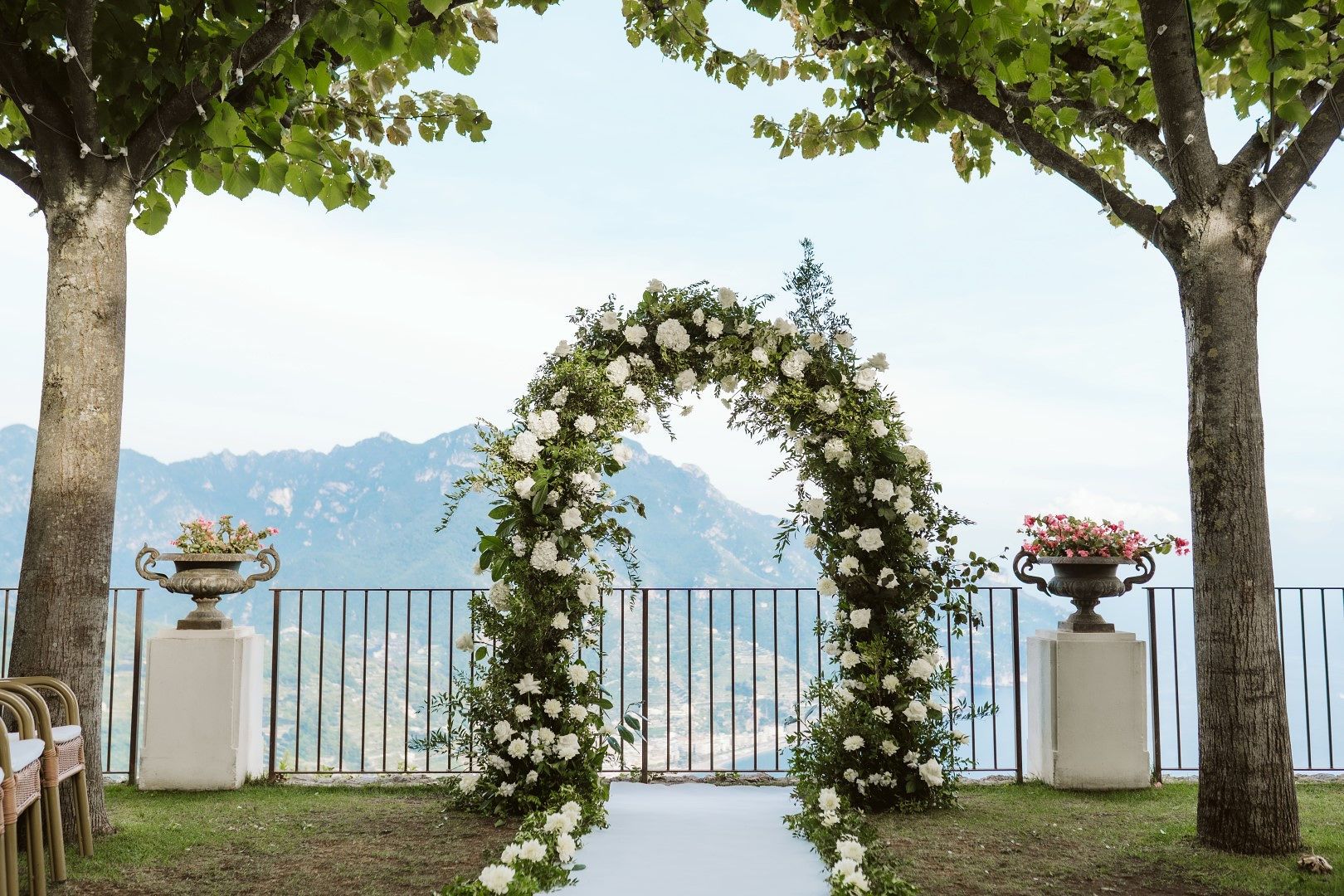 Floral wedding arch for the ceremony of an elopement in Italy with the Amalfi Coast in the background.