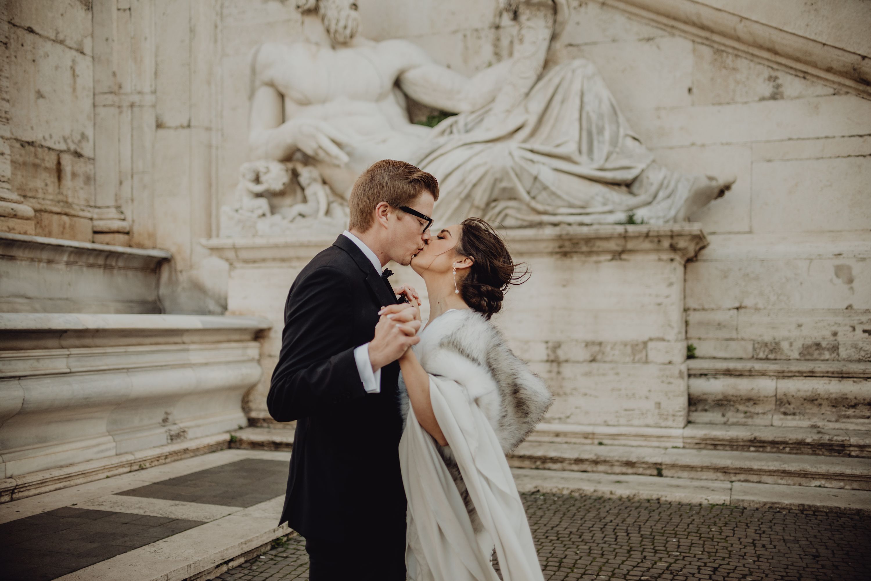 Newlyweds kissing during a romantic photoshoot in the streets of Rome of their destination wedding in Italy
