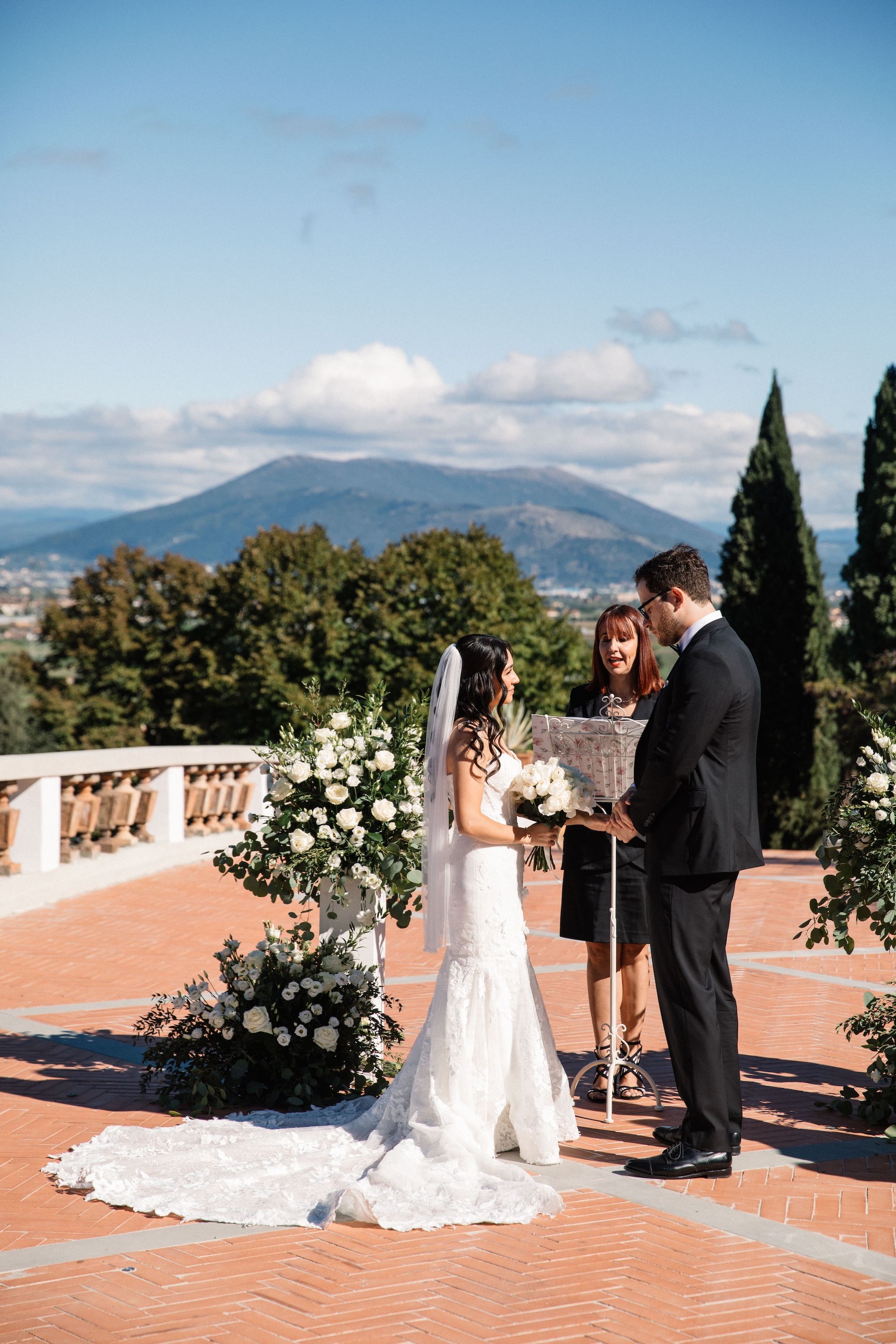 Bride and groom are reciting their vows during the outdoor ceremony of their vow renewal in Italy