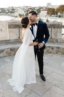 Newlyweds kissing on top of a castle turret overlooking the beach during the photoshoot of their small wedding in Portugal
