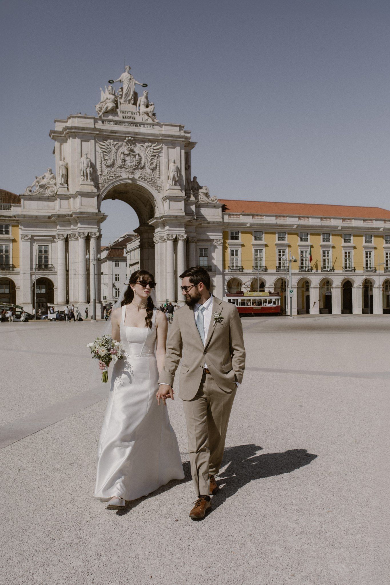 Bride and groom walk along the streets of the city center of Lisbon during their small wedding in Portugal