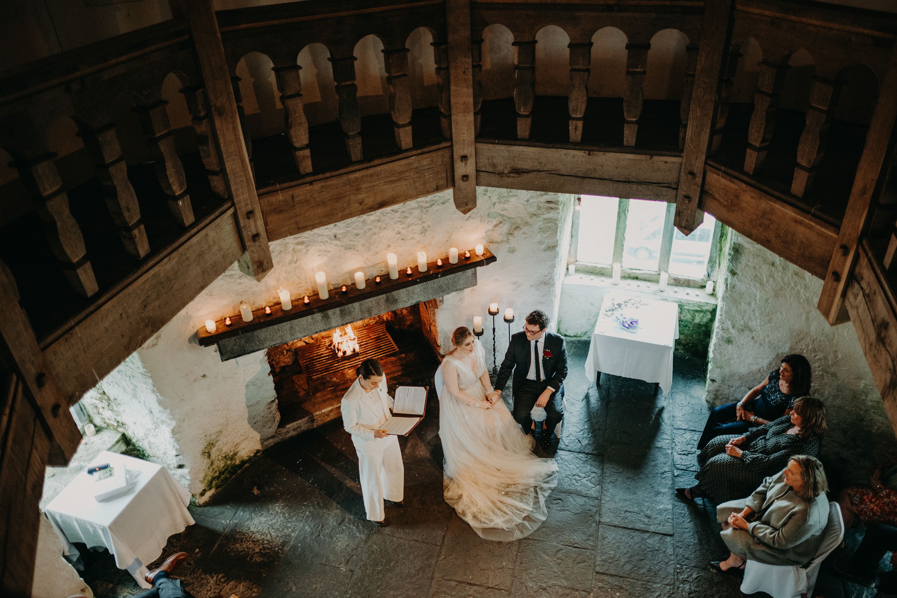 Overhead view of a candlelit stone hall hosting a small wedding in Ireland