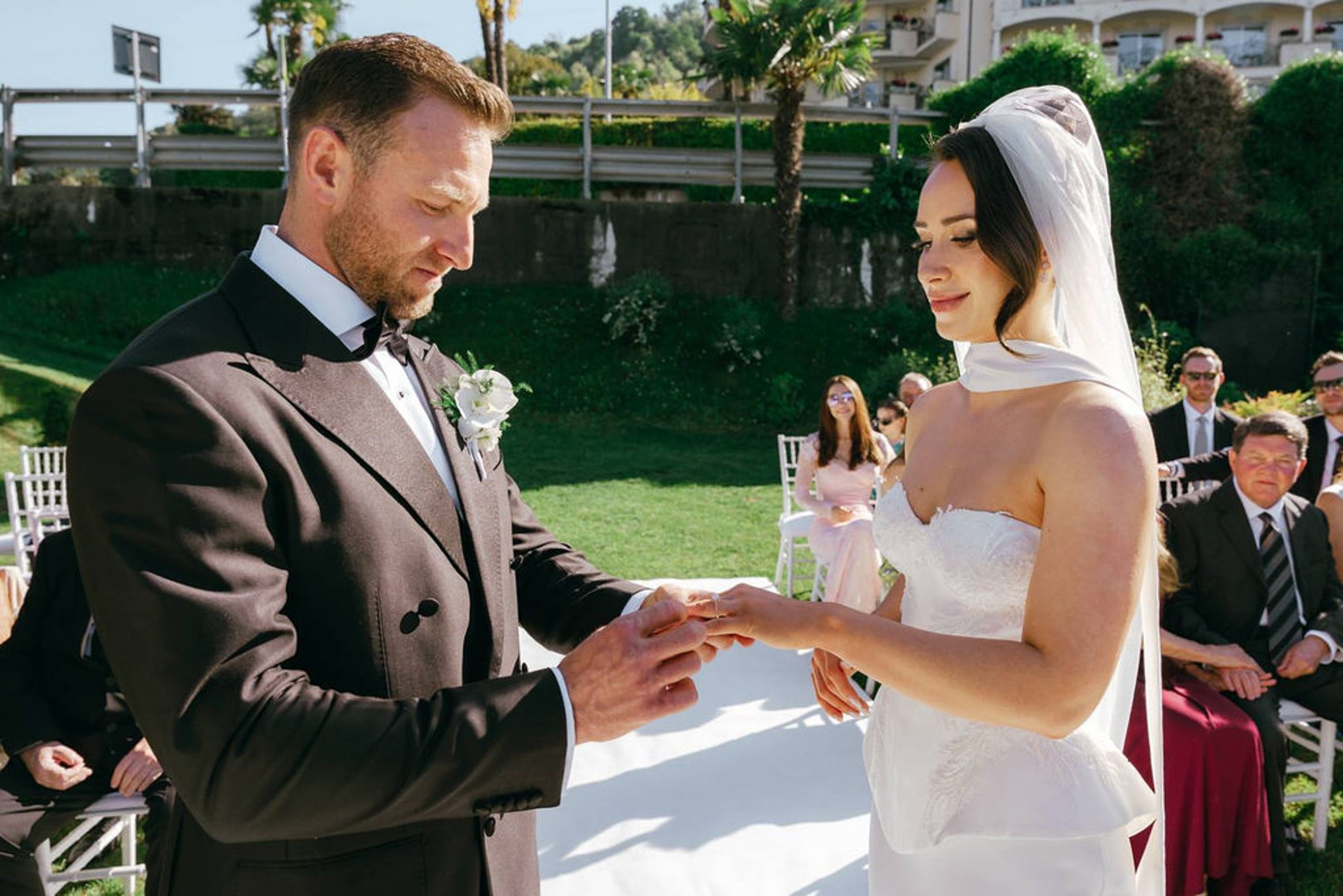 Groom placing a wedding ring on the bride's hand during an intimate wedding in Italy