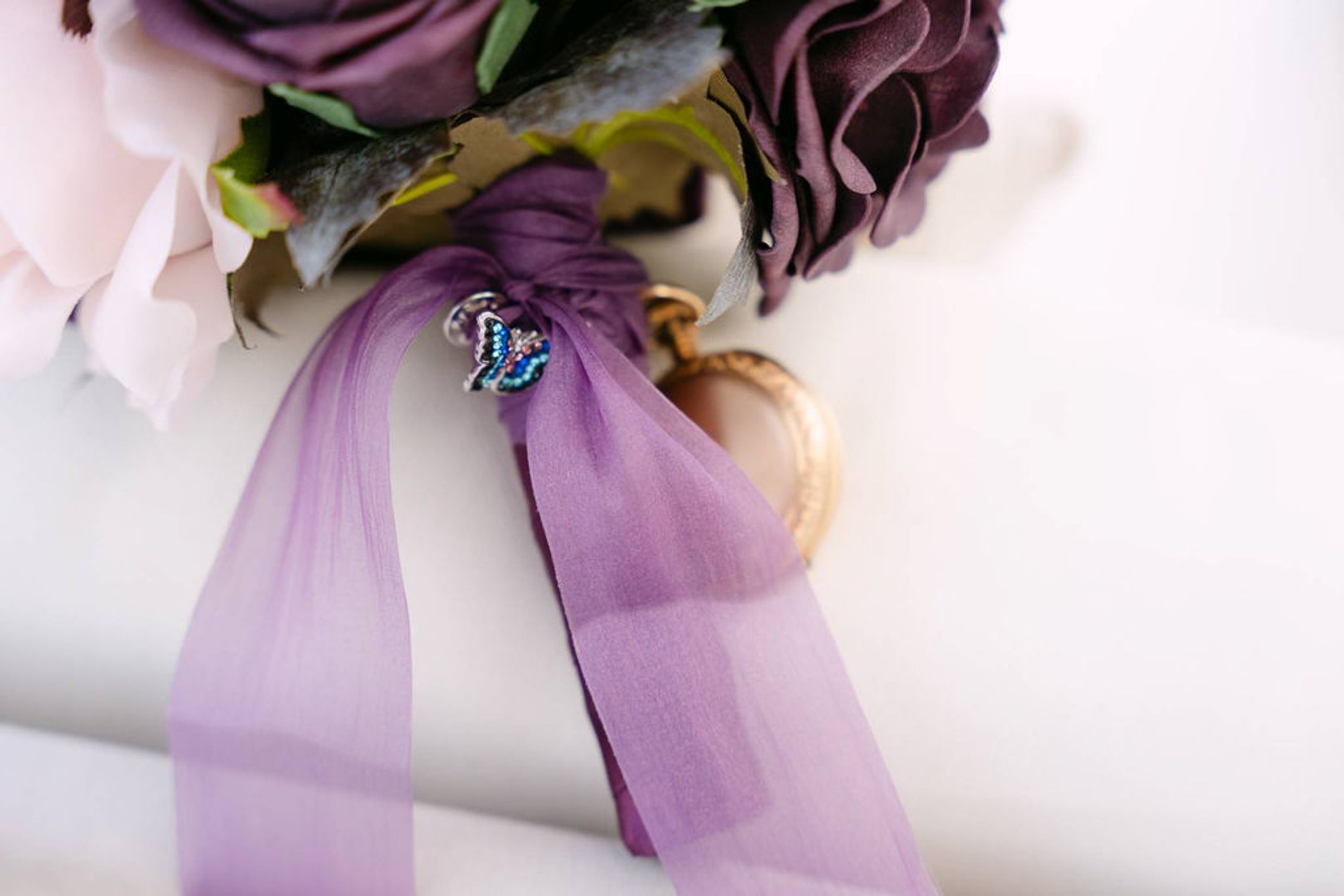 Close-up of bridal bouquet ribbon and vintage pocket watch details from an intimate wedding in Italy