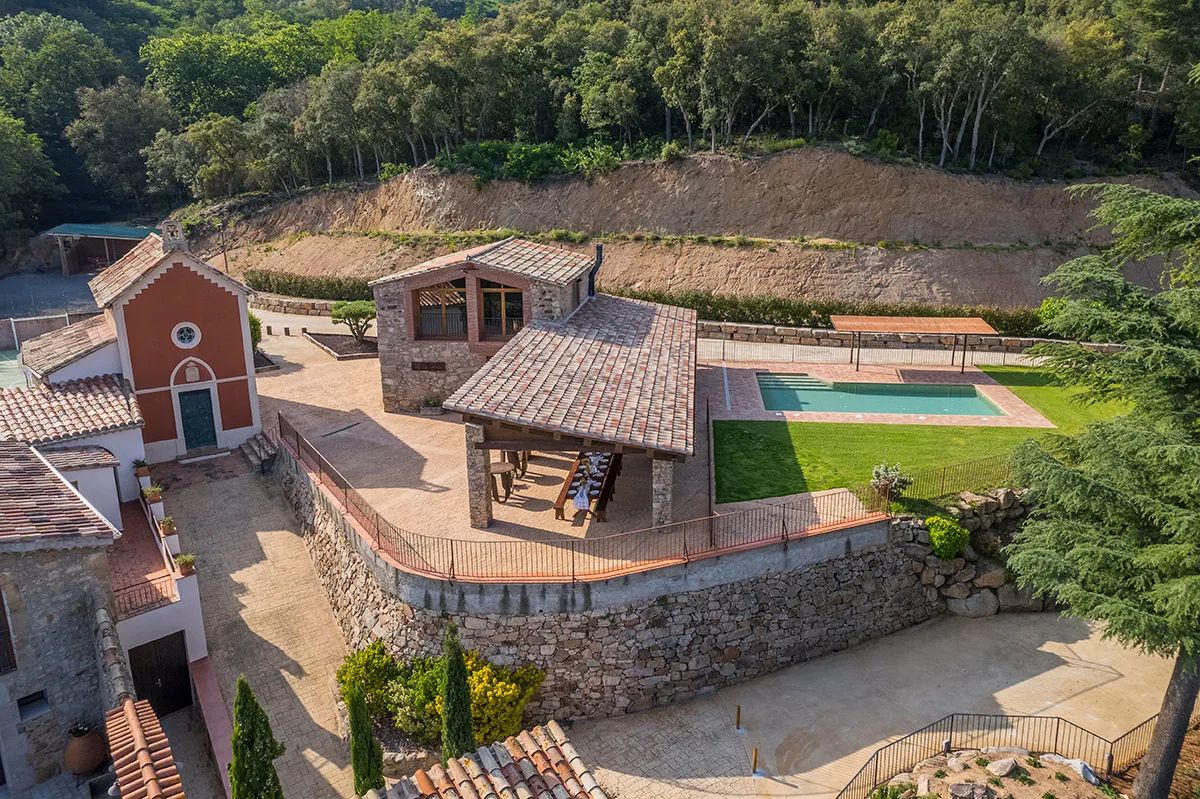 A medieval country house with a pool surrounded by trees in Girona, Spain