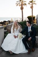 Groom looks at his bride with the beach and the Cascais coast in the background during their micro wedding in Portugal