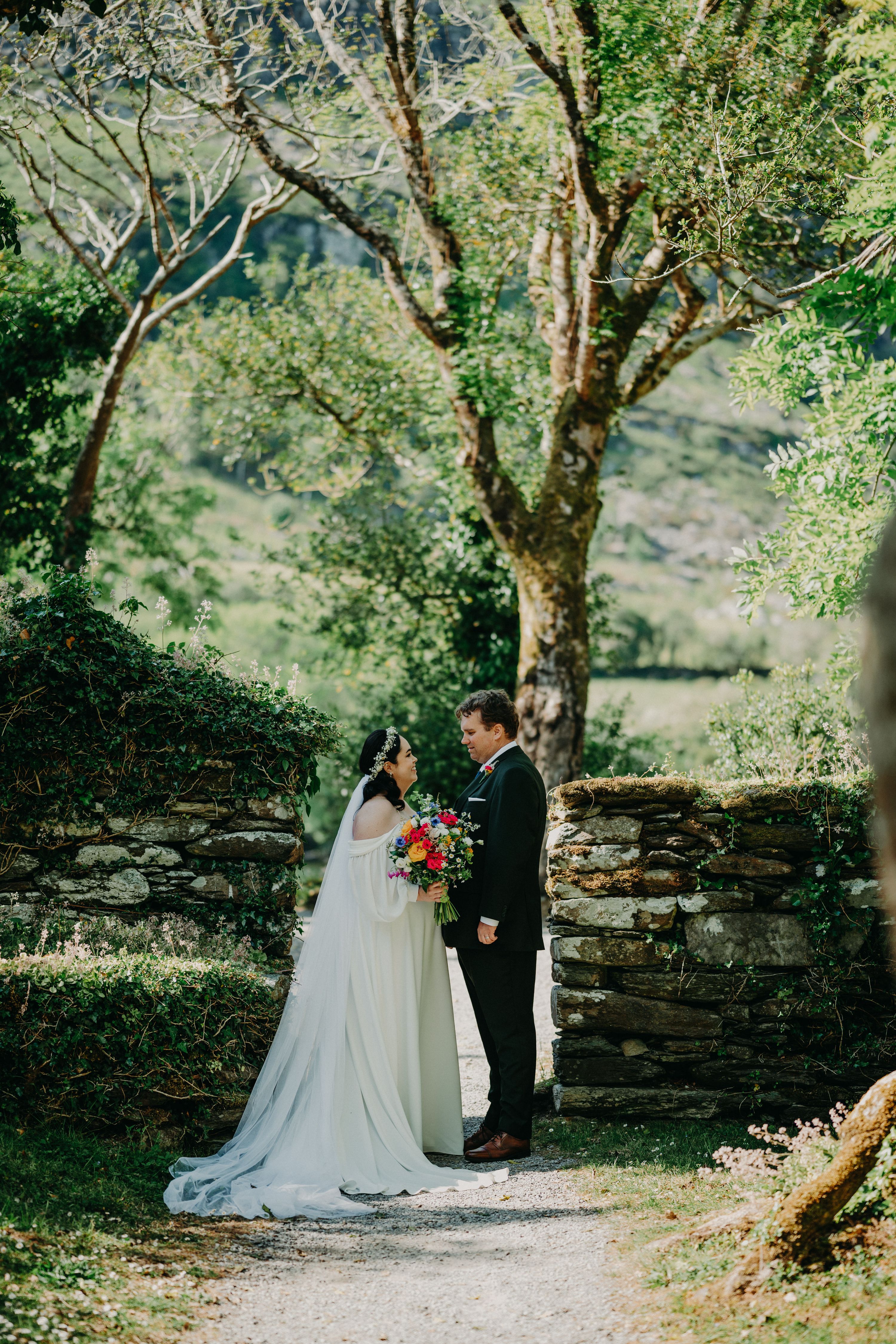 Newlyweds looking at each other with lush Irish nature in Cork during the photoshoot of their small wedding in Ireland