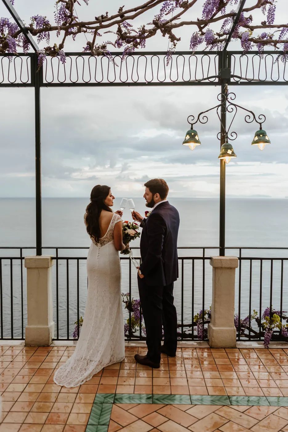Bride and groom looking at each other at a terrace overlooking the Tyrrhenian Sea during thier elopement in Italy