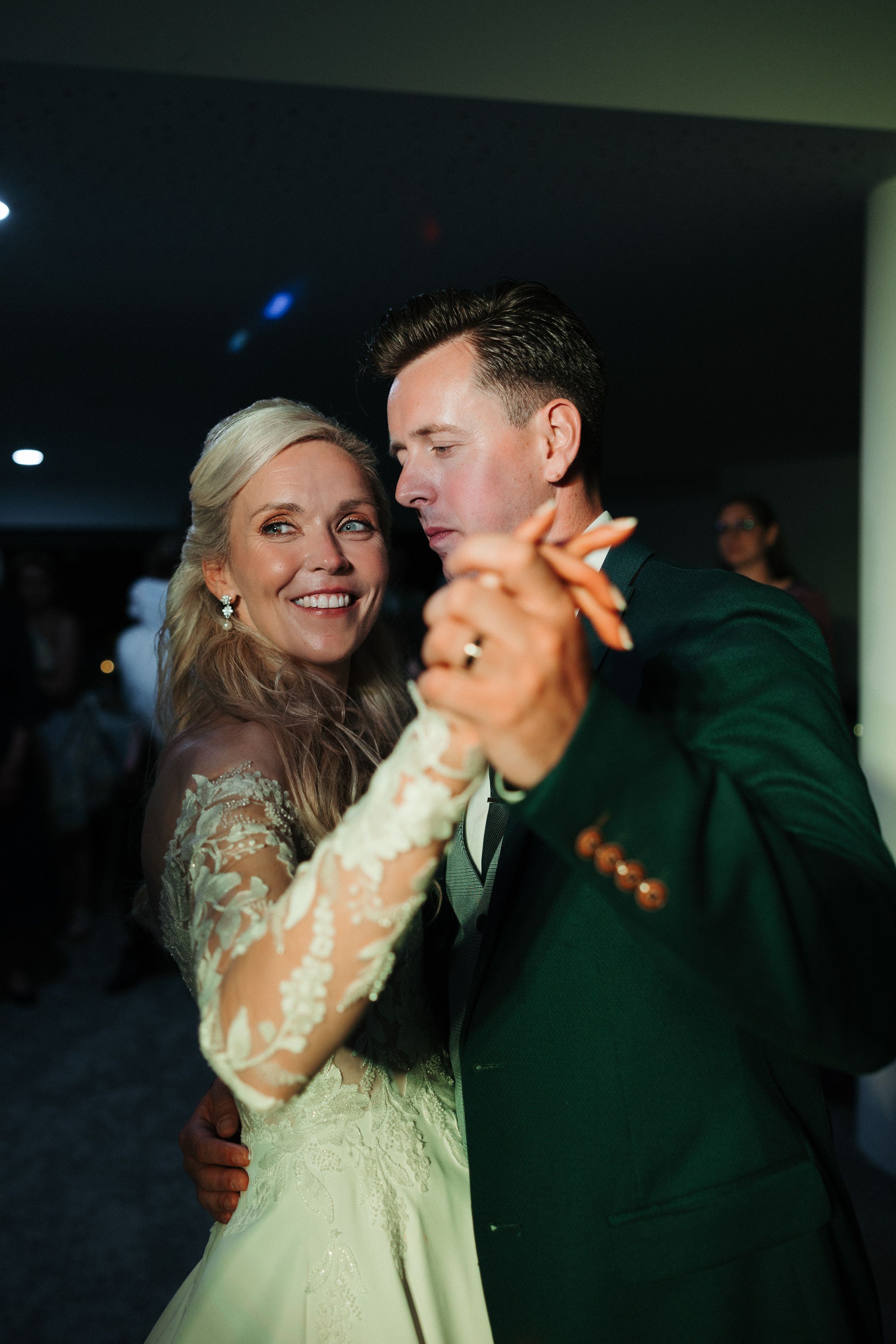 Bride and groom slow dancing under party lights during a small wedding in Portugal reception