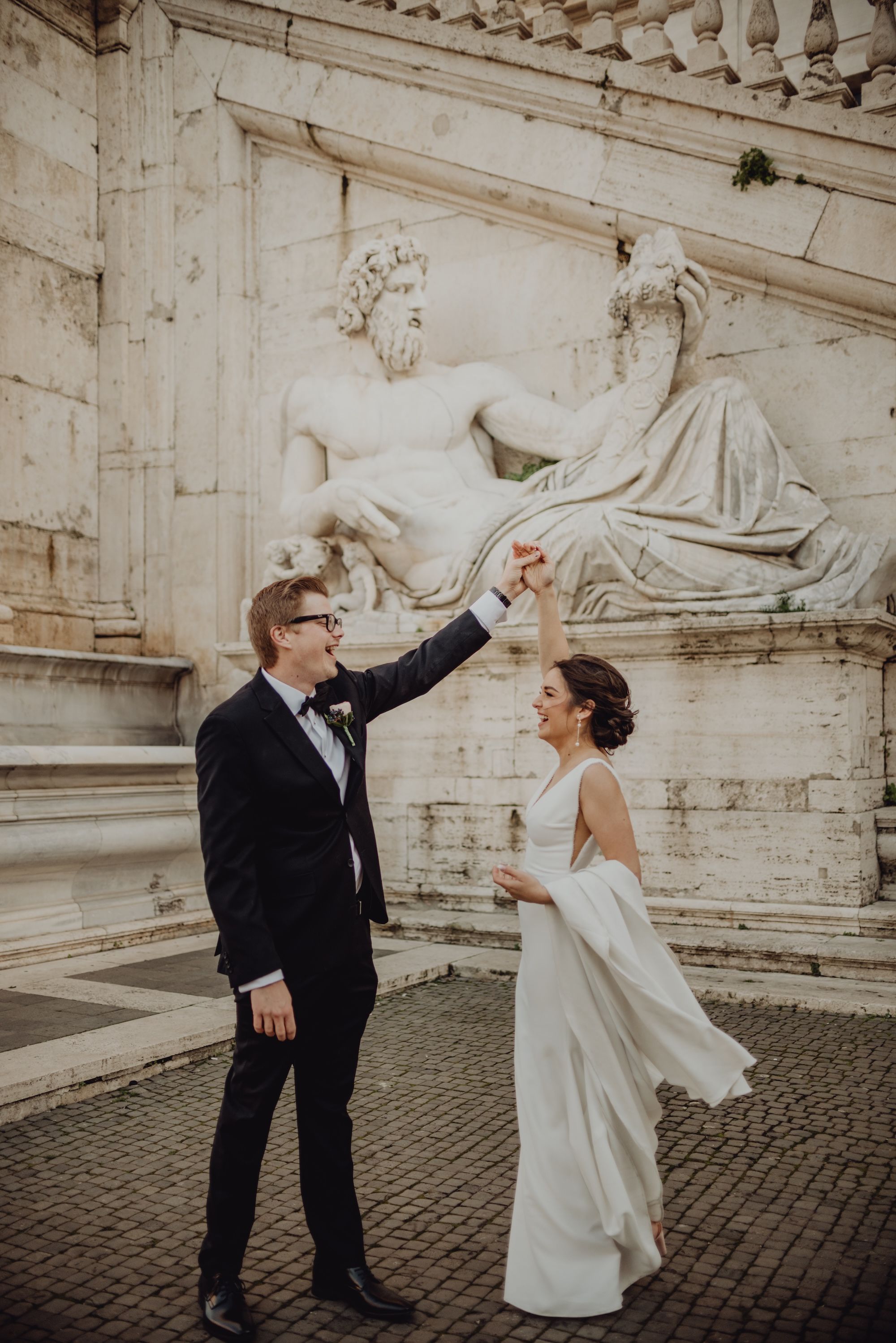 Groom spinning his bride around in an outdoor spot in Rome during their elopement in Italy