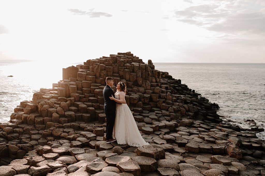 The Giant’s Causeway and the wild Atlantic Ocean in the background of the newlyweds during their elopement in Ireland