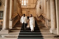 Newlyweds going down the stairs of a museum in Turin after the ceremony of their elopement in Italy
