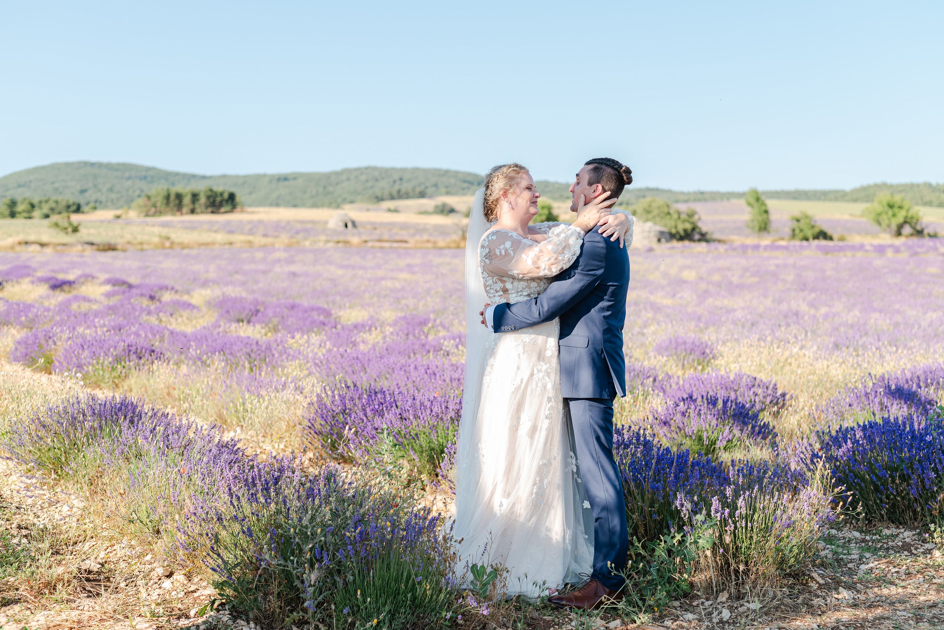 Newlyweds embracing in a blooming lavender field at a small wedding in France